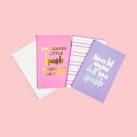 Three notebooks with motivational quotes on a pink background